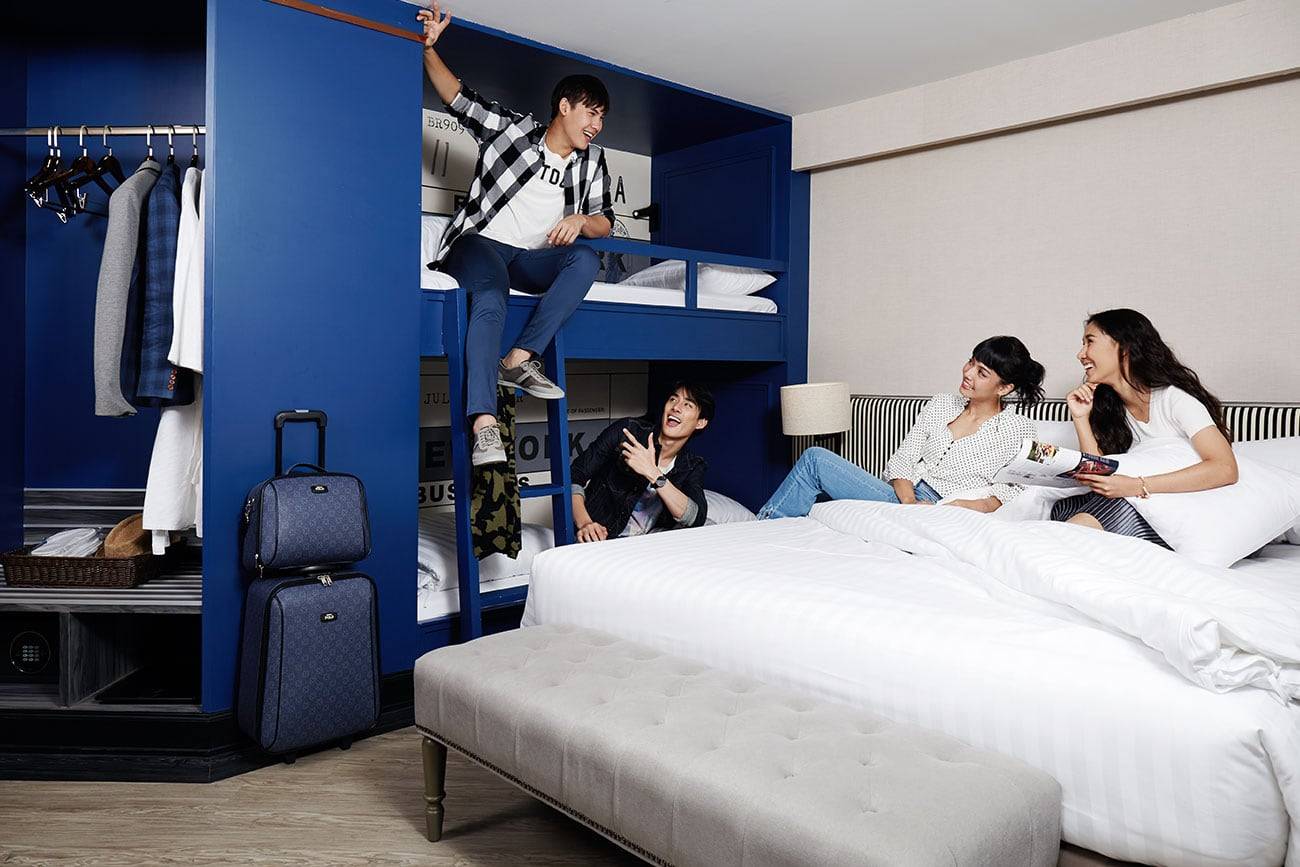 Family Journey room at Vince Hotel with royal blue walls, king bed and bunk bed