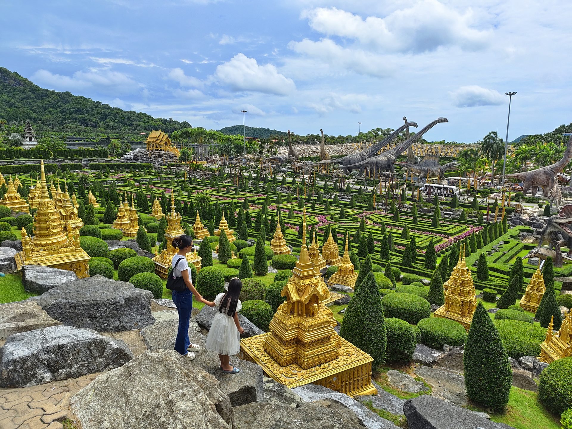 Visitors among themed gardens and golden decorations at Nong Nooch