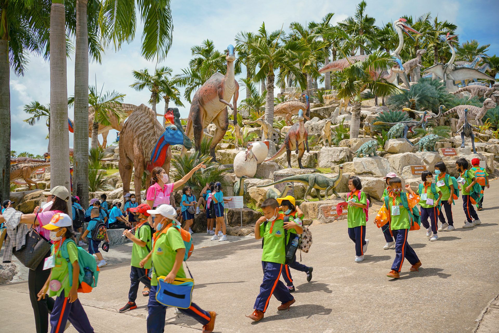 Visitors walking among life-sized dinosaur displays in Dinosaur Valley at Nong Nooch