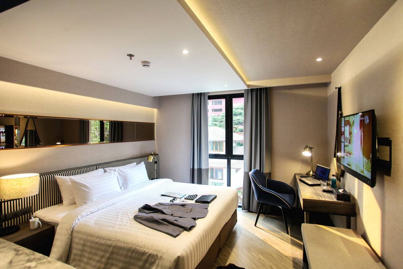Deluxe Discovery guest room at Vince Hotel with king bed, desk and warm lighting