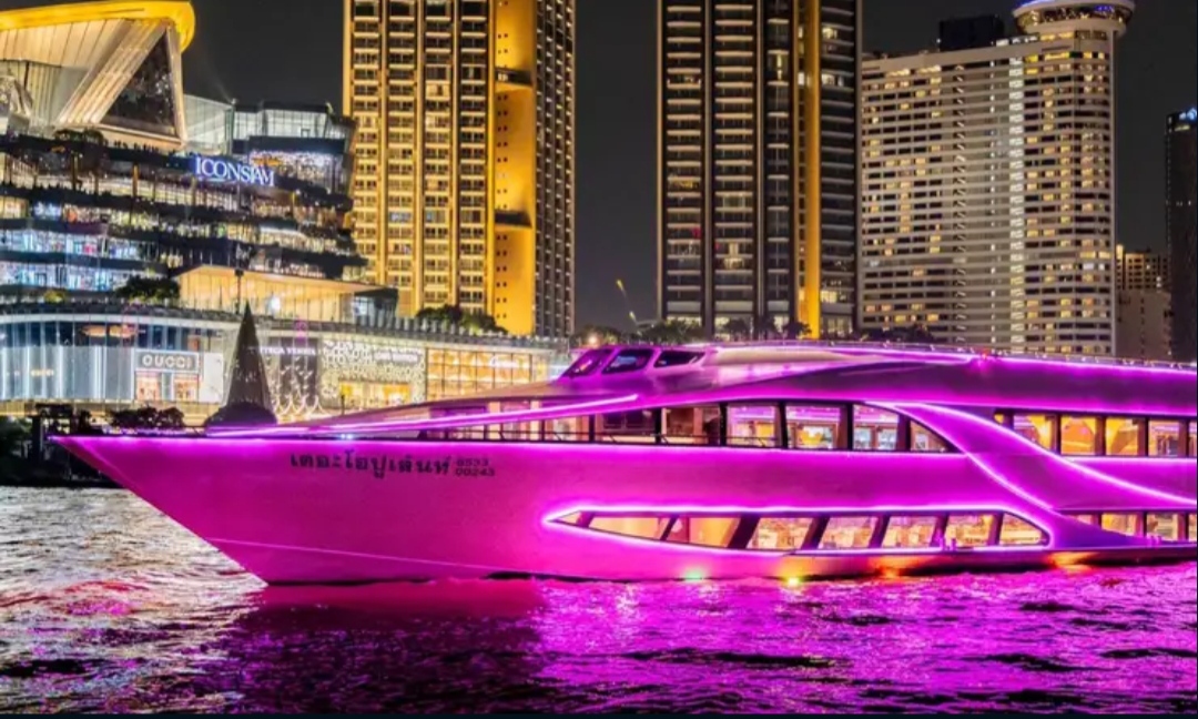 The Opulence Cruise illuminated in magenta on the Chao Phraya River at night near ICONSIAM