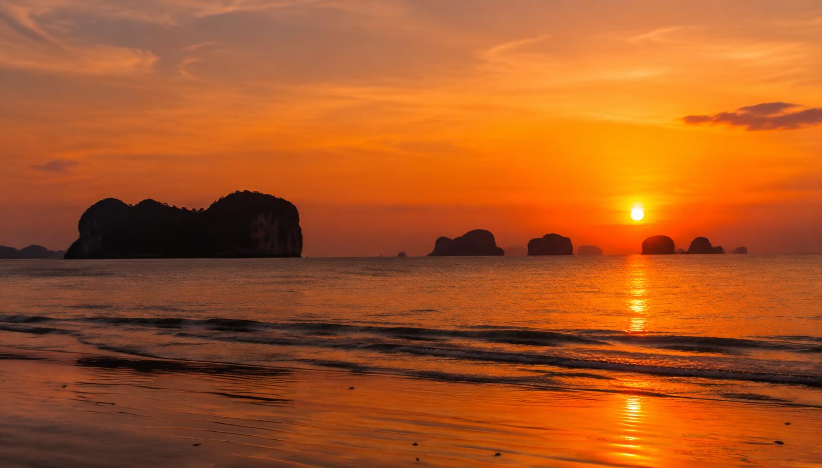 Silhouetted limestone islands on the horizon at sunset over the Andaman Sea near Krabi