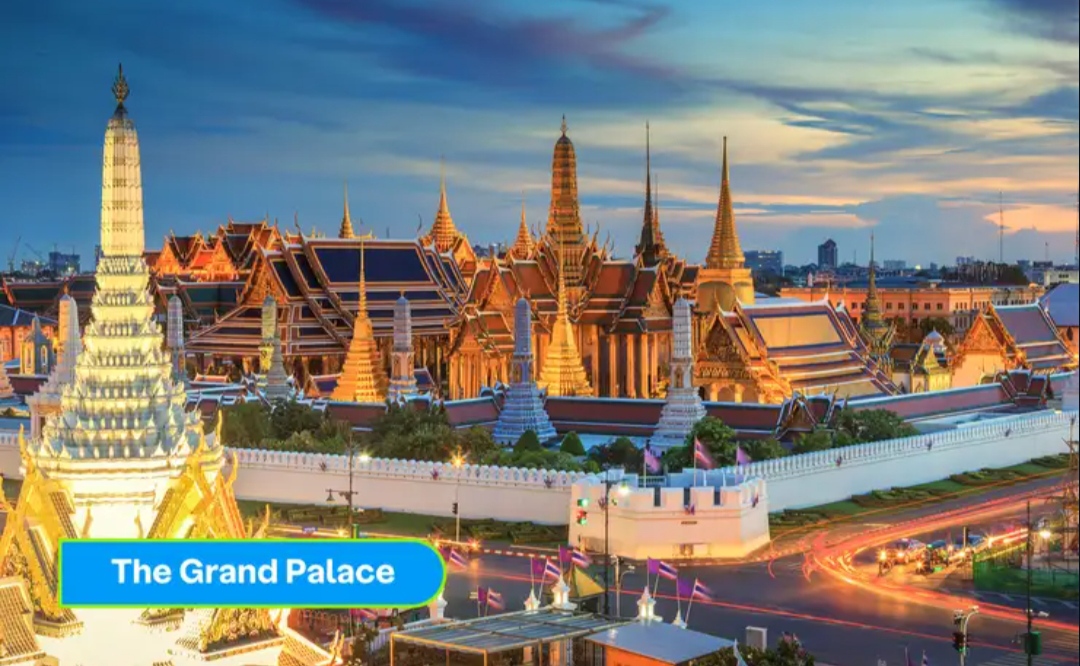The Grand Palace illuminated against the Bangkok evening sky